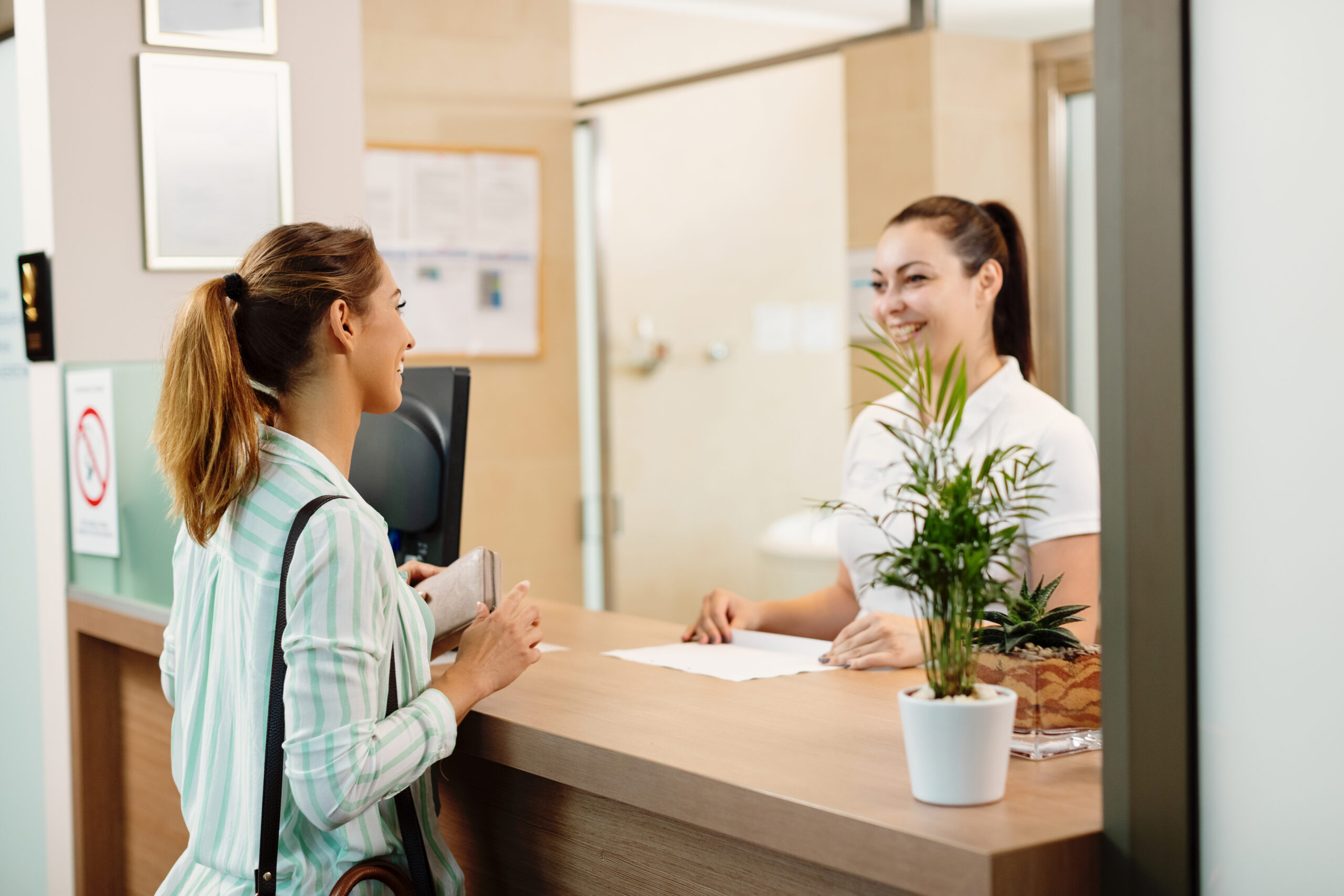 Woman speaking with a receptionist about nipple bleaching treatment.